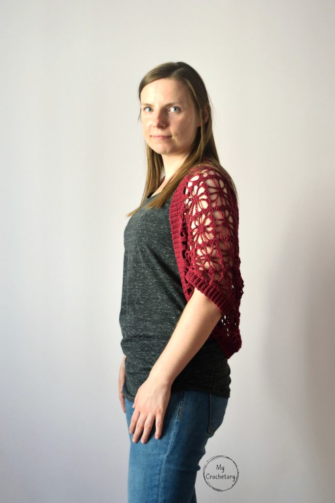Side view of model wearing crochet shrug pattern with lace detail.