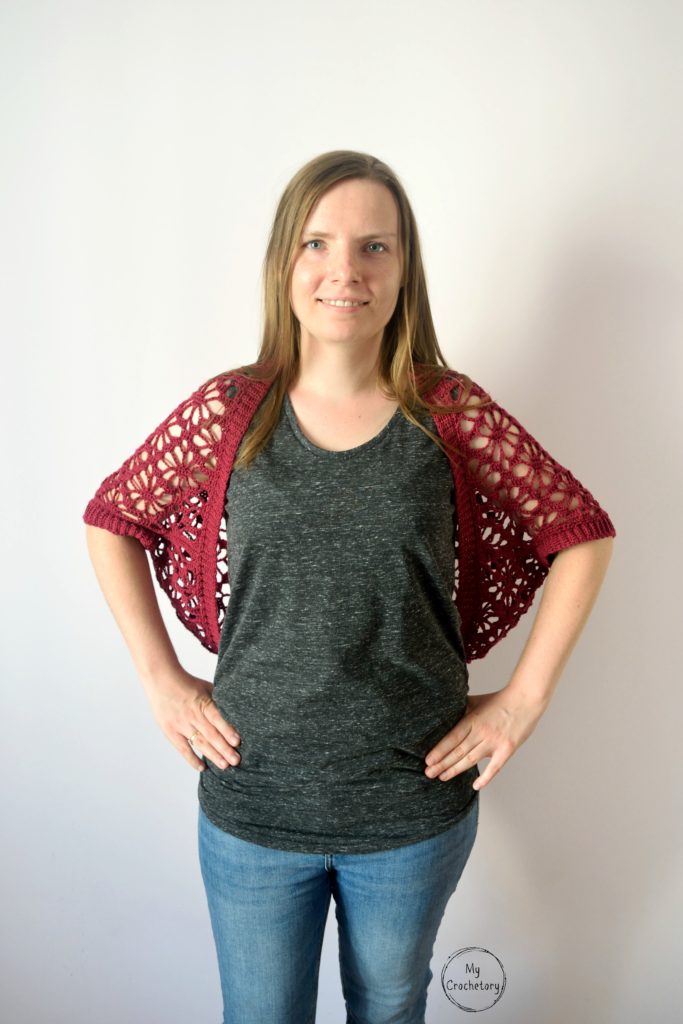 Front view of model wearing a crochet shrug pattern with intricate lace detail.