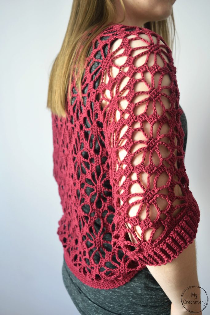 Side profile of a crochet shrug pattern highlighting floral lacework.