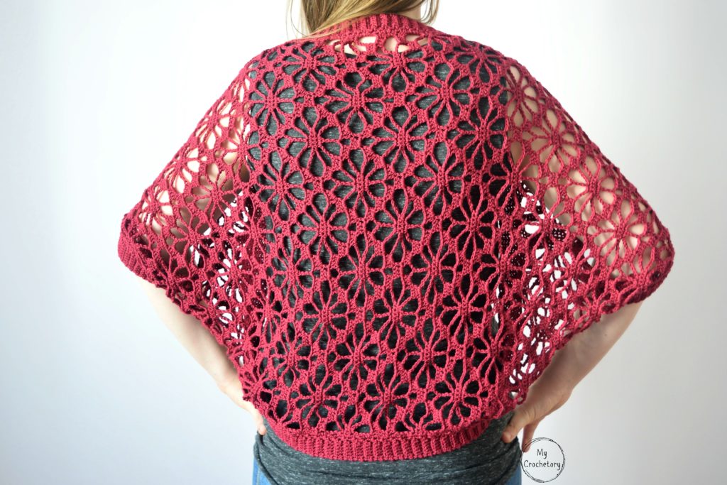 Back close-up of lace crochet shrug pattern with floral motifs.