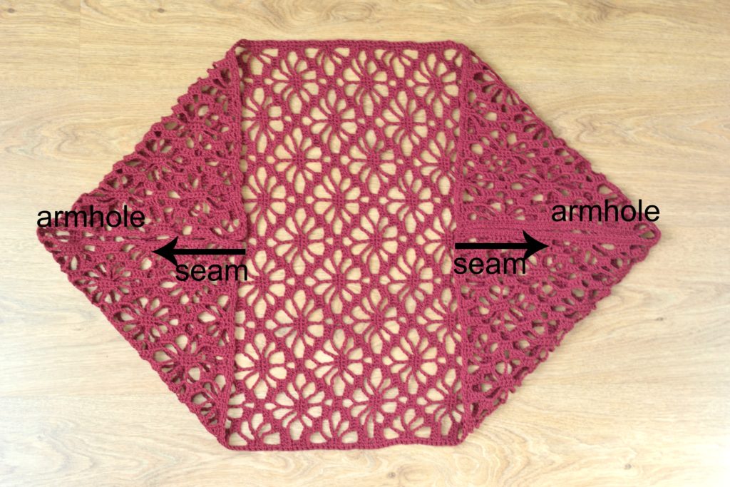 Folded crochet shrug pattern showing armholes and seams for assembly.