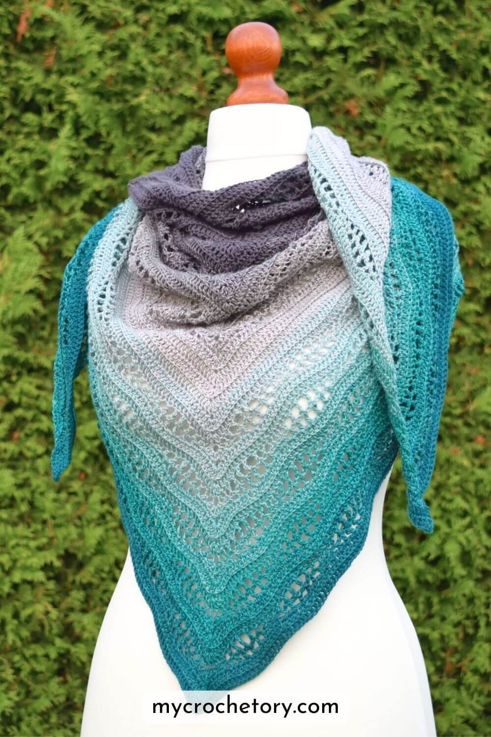 Kalinda Shawl crochet pattern – triangle shawl with wavy lace texture in gradient teal and grey yarn, displayed on mannequin by MyCrochetory.