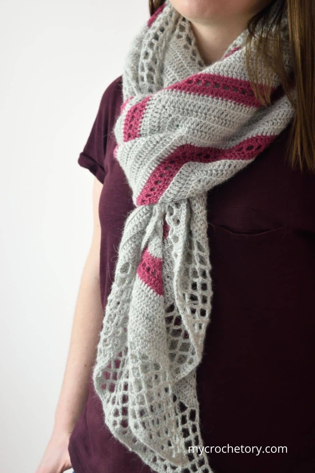 Spring Solstice Wrap worn wrapped around the shoulders, showing the gray and pink crochet trapezoid shawl