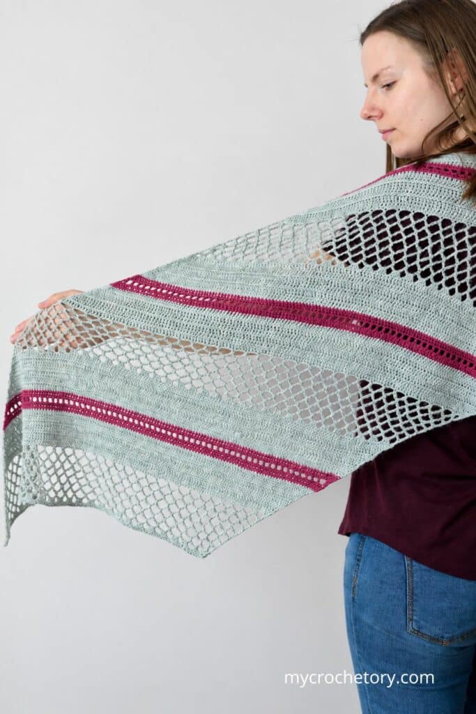 Woman holding the Spring Solstice Wrap open, showing the full trapezoid shape