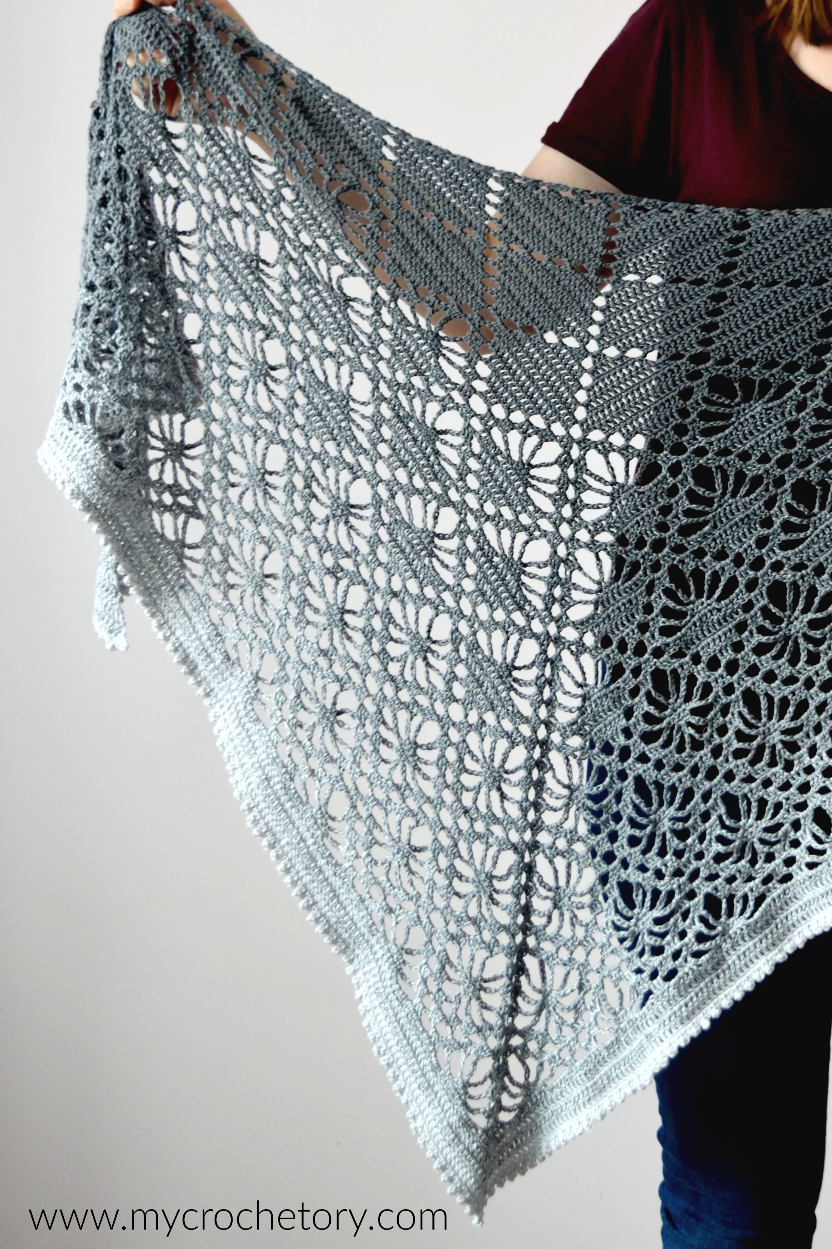 Close-up of the diamond lace in the Leto crochet shawl, held open