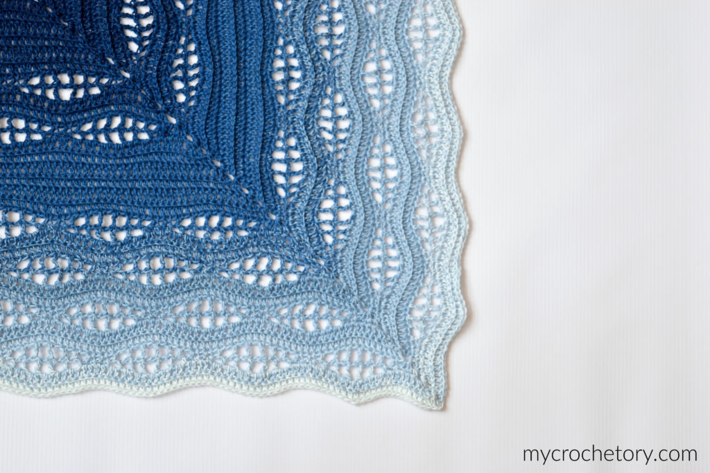How to crochet a blanket: a beautiful Kalinda Blanket showcasing vibrant waves of color.