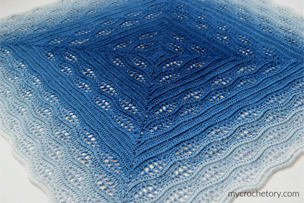 How to crochet a blanket: a beautiful Kalinda Blanket showcasing vibrant waves of color.