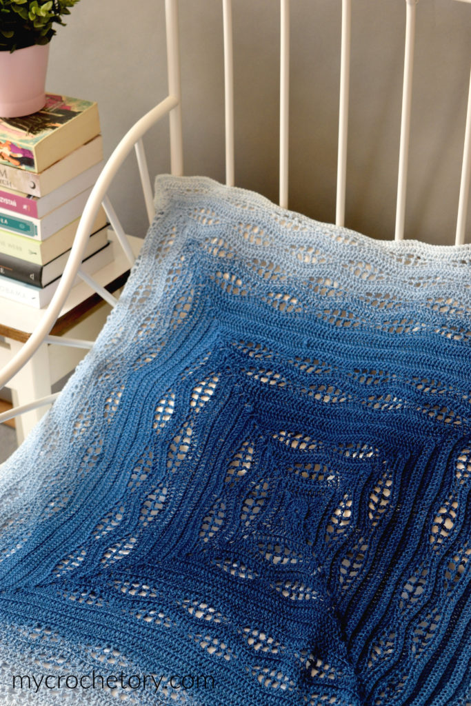How to crochet a blanket: a beautiful Kalinda Blanket showcasing vibrant waves of color.