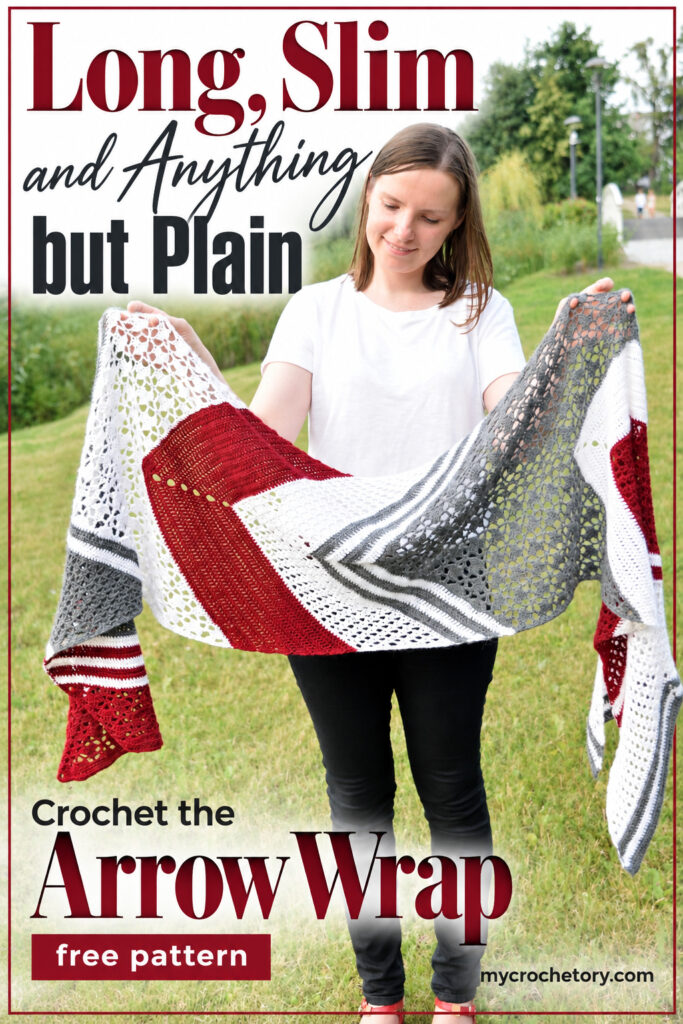 Long, slim and anything but plain pin with a woman holding the red, white and gray Arrow Wrap open, free pattern