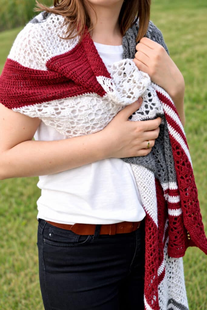 Striped lace wrap worn like a shawl and held together at the chest