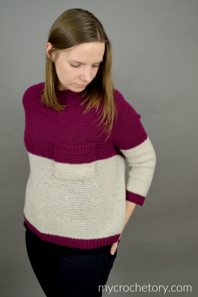 Pocket Raglan crochet sweater in burgundy and cream with a chest pocket