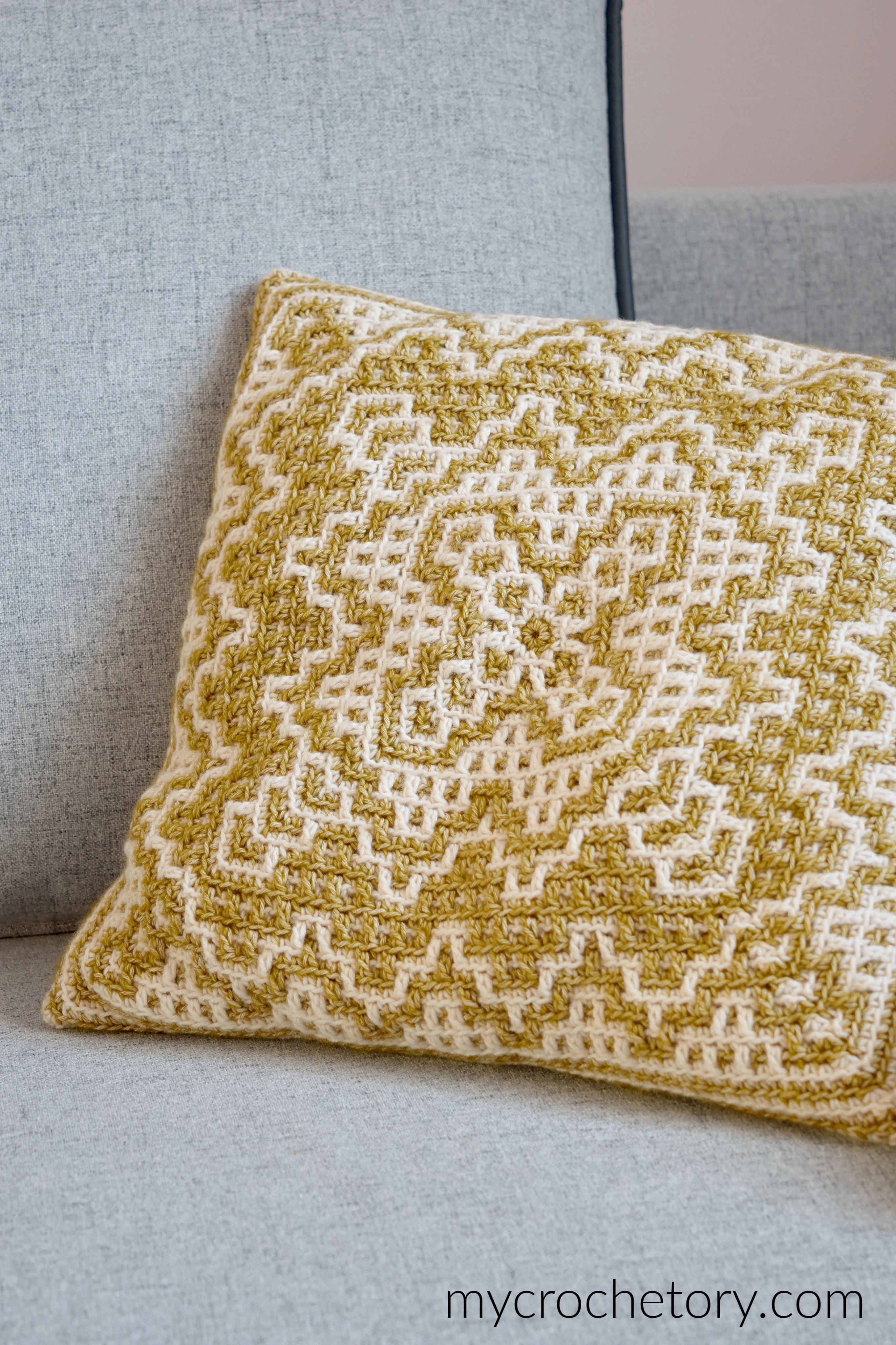 Dioon Pillow, mustard and cream mosaic crochet pillow on a gray sofa