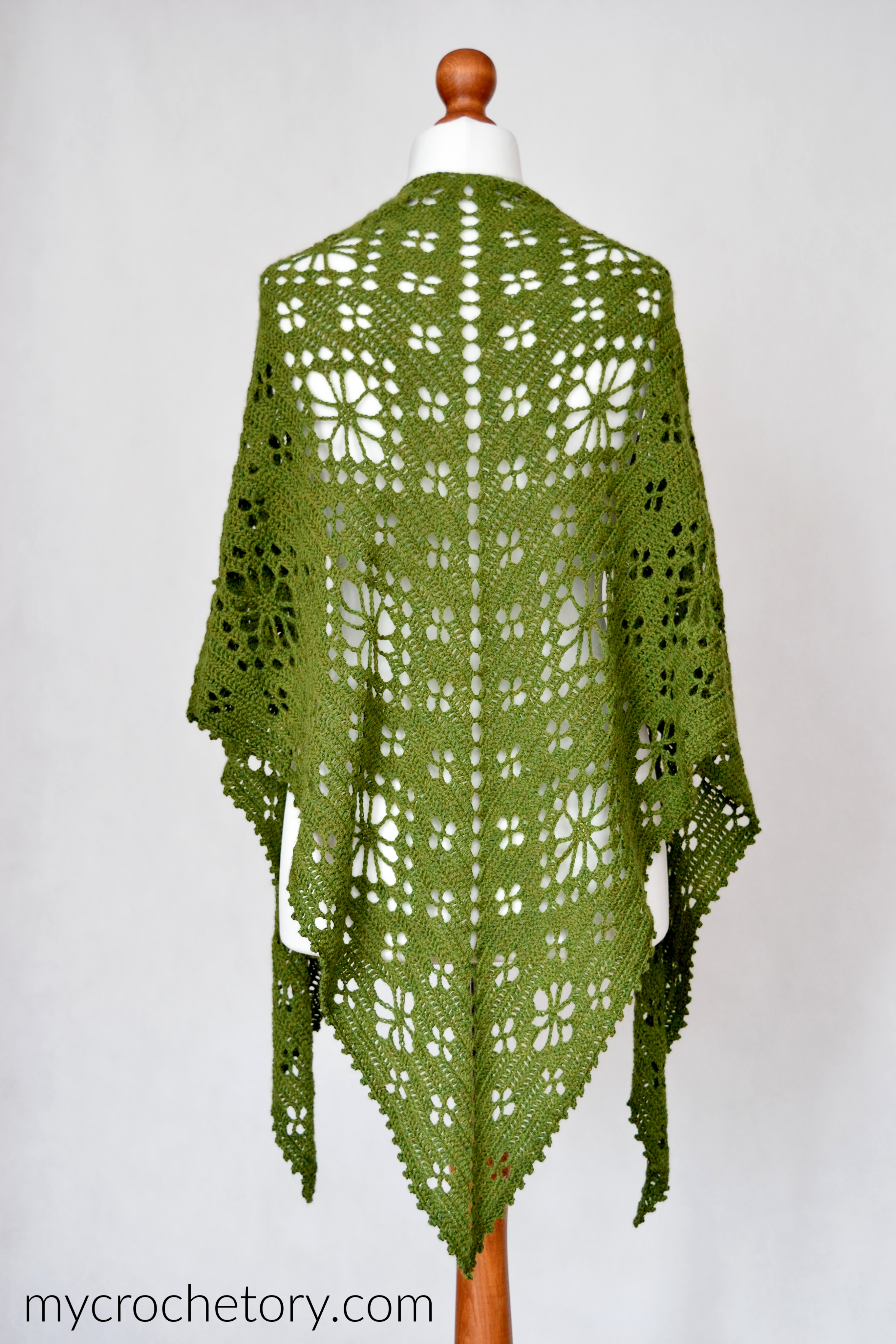 Back view of the green top-down flower shawl on a mannequin