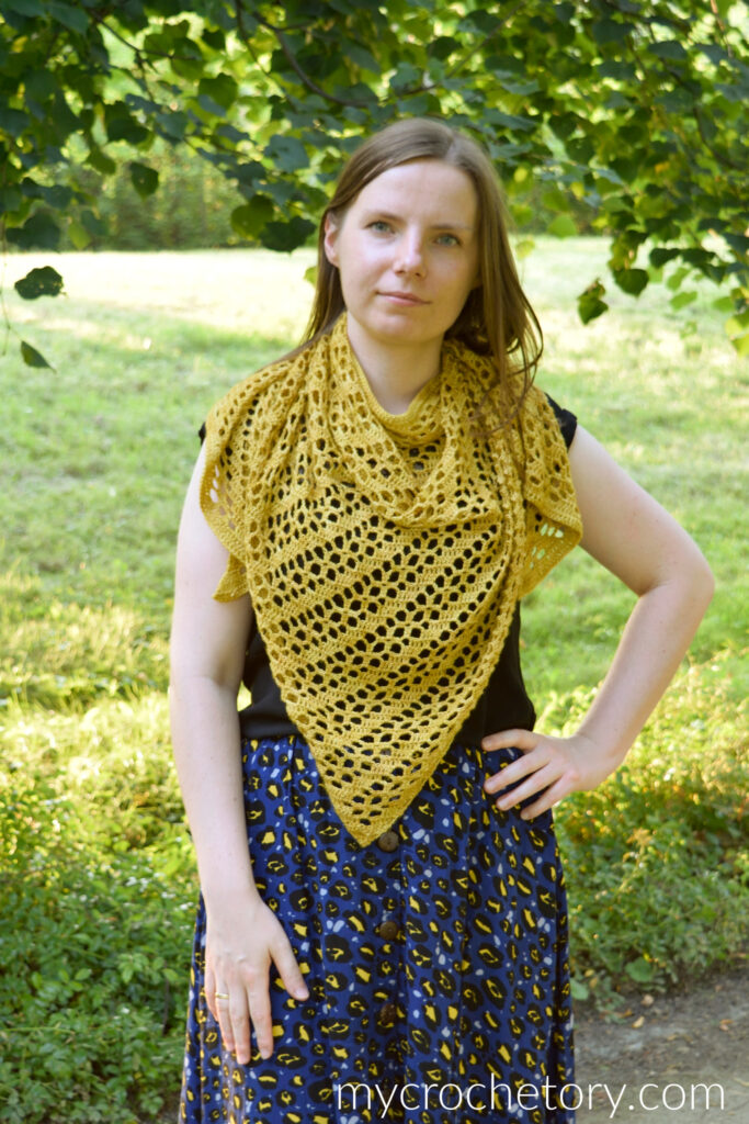 Mustard yellow crochet shawl with diagonal lace bands, worn with a long navy skirt