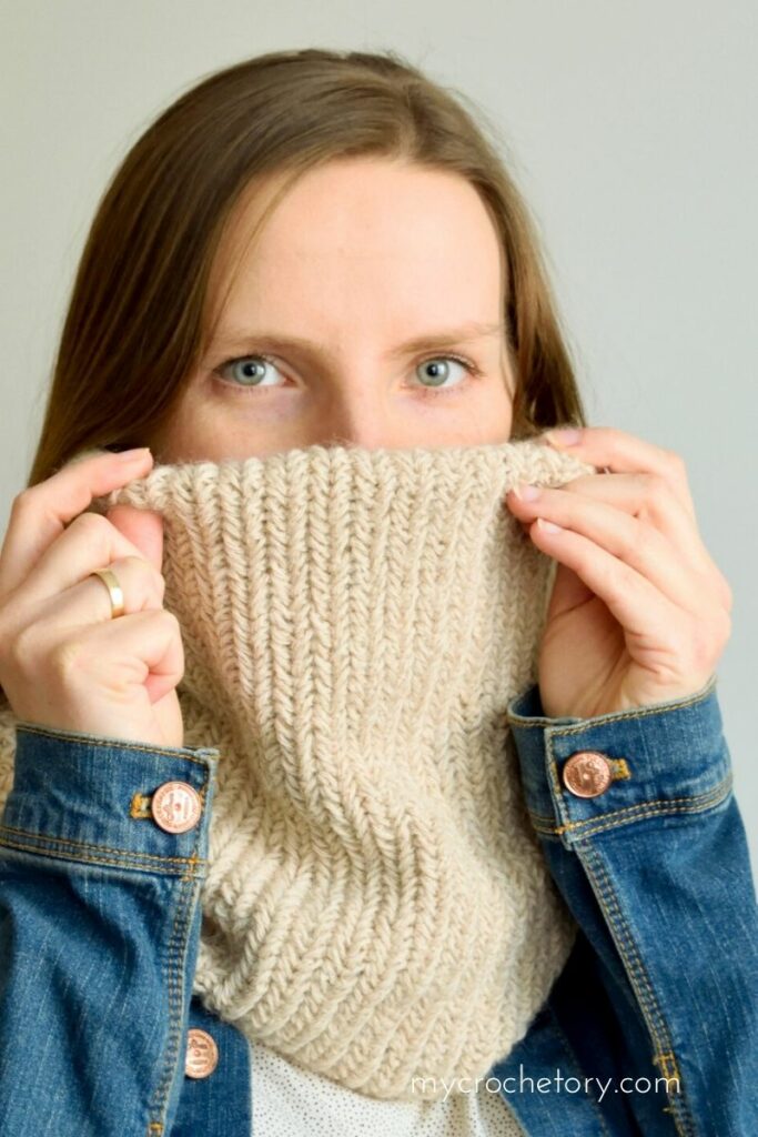 Woman wearing beige herringbone crochet cowl made with DROPS Puna yarn, free crochet neck warmer pattern by MyCrochetory