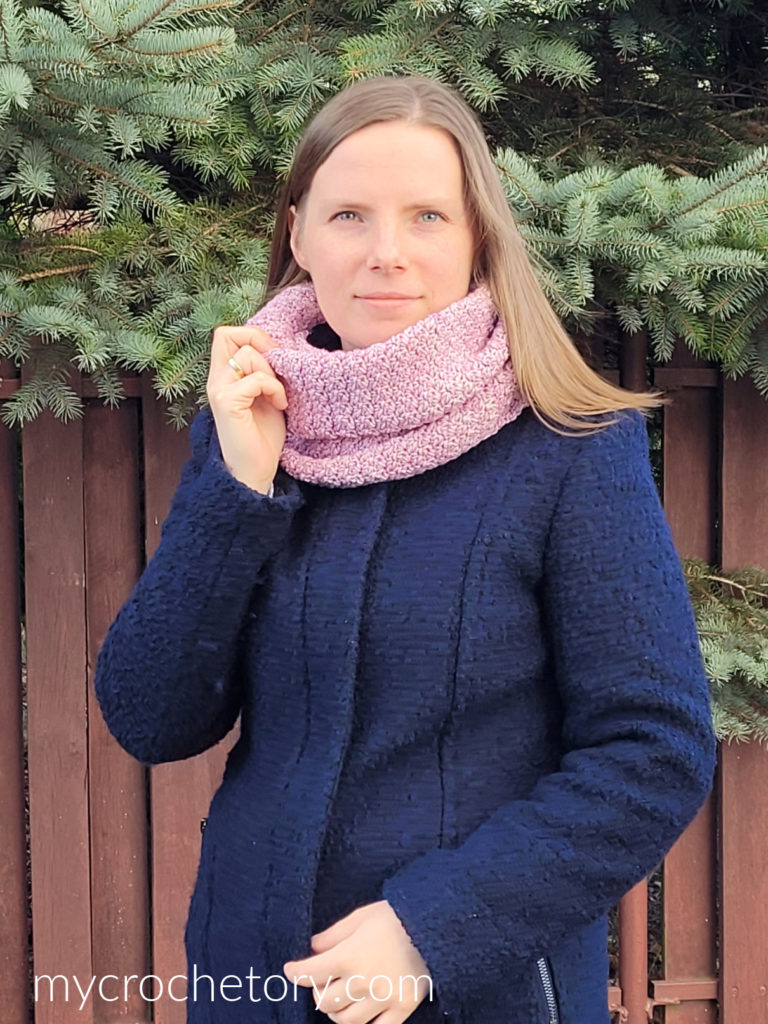 Valentina crochet infinity scarf in dusty pink, worn with a navy coat outdoors