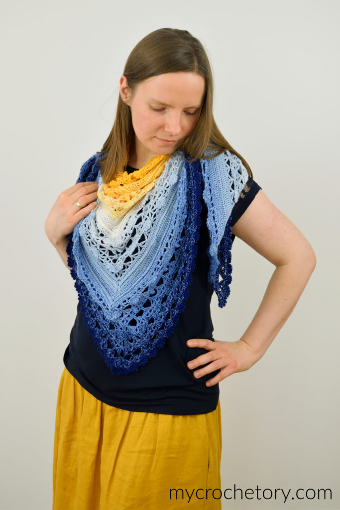Avis crochet triangle shawl pattern worked in gradient yarn of fingering weight yarn.