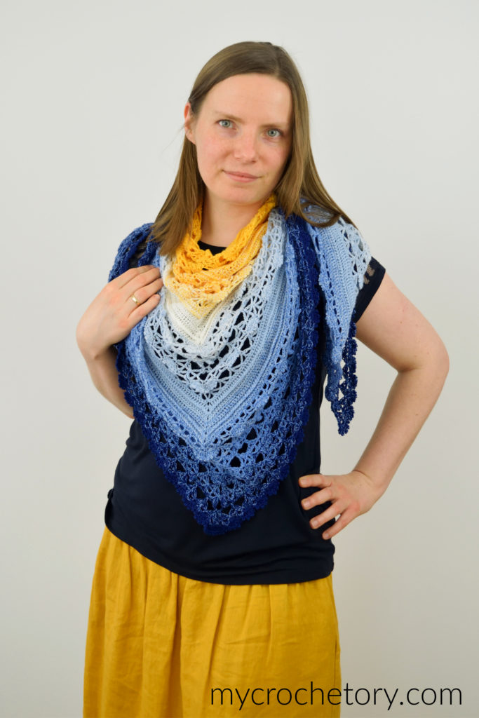 Avis crochet triangle shawl pattern worked in gradient yarn of fingering weight yarn.