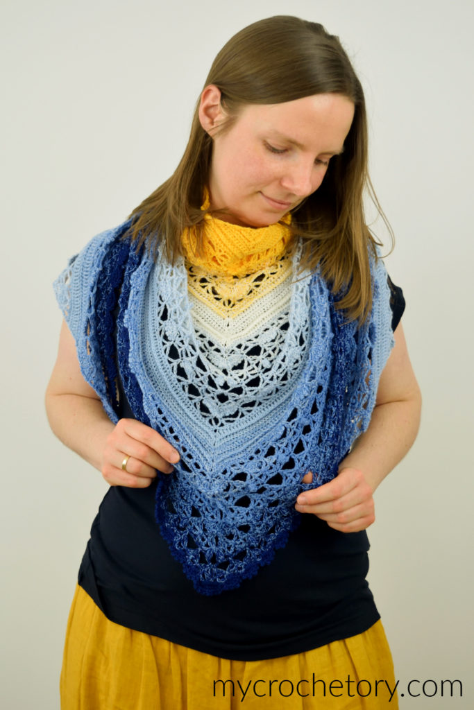 Avis crochet triangle shawl pattern worked in gradient yarn of fingering weight yarn.