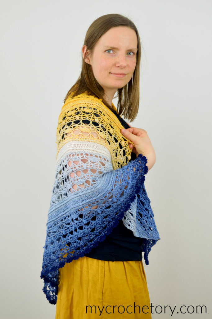 Avis crochet triangle shawl pattern worked in gradient yarn of fingering weight yarn.