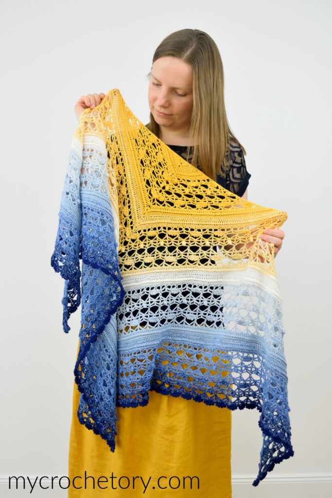 Avis crochet triangle shawl pattern worked in gradient yarn of fingering weight yarn.