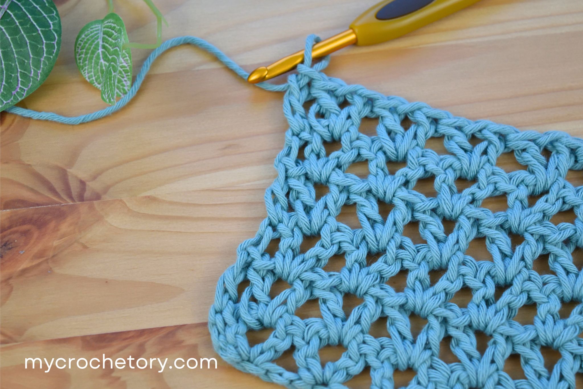 Blue V-stitch crochet swatch with a crochet hook