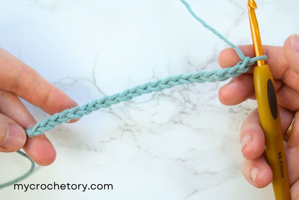 How to crochet V-stitch: A chain of stitches forming the foundation for the V-stitch.