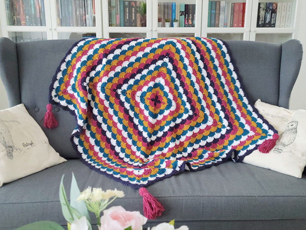 See how do I crochet magic circle to start the colorful clamshell square blanket, perfect for home decor.
