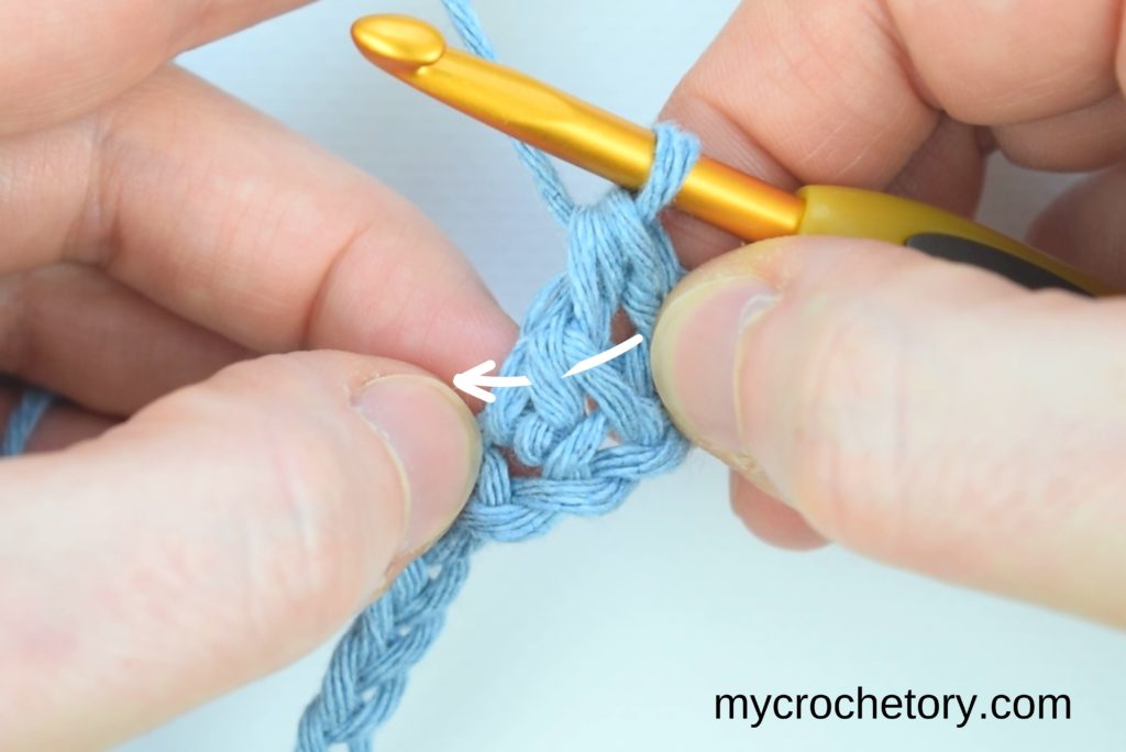 Guiding through the next steps by instructing to yarn over and insert the hook into the small slanted loop of the bottom half double crochet.