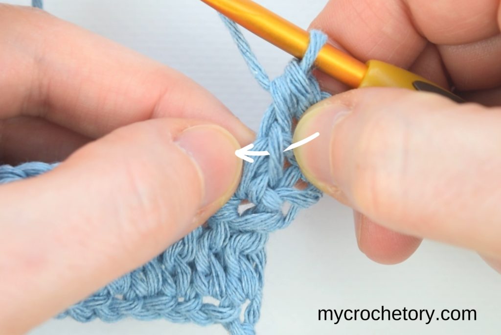 Guidance on making the next stitches, involving the yarn-over and hook insertion into the small slanted loop.