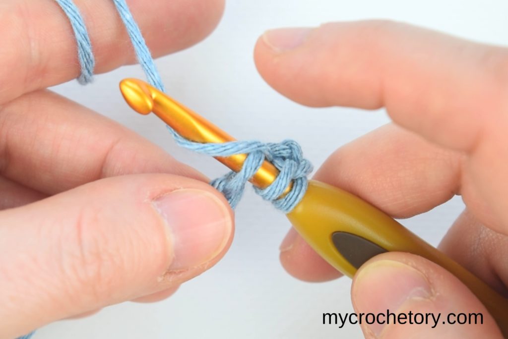 Illustrating the continuation of the yarn-over process and hook insertion into the next chain, resulting in five loops on the hook.