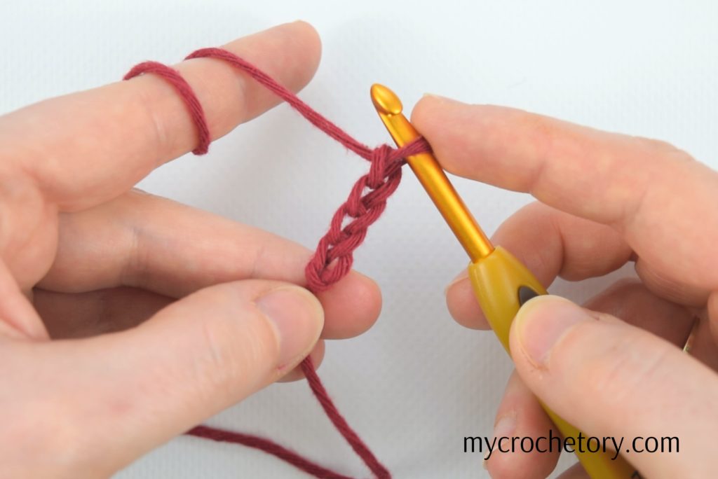 Hands holding completed crochet chains – a visual guide on how to crochet a chain for beginners.