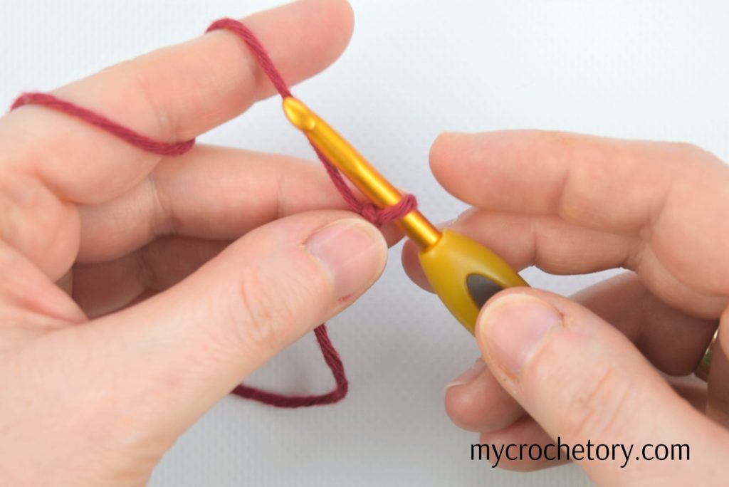Hands holding slip knot - Learn how to crochet a chain with ease in our tutorial.
