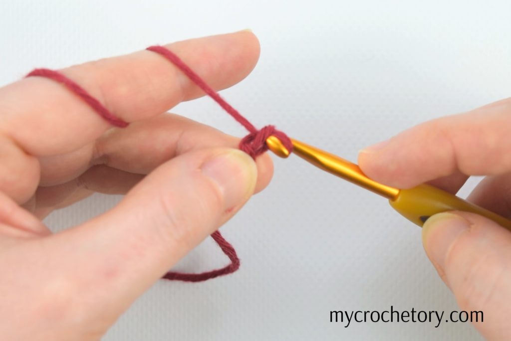Hands demonstrating 'how to crochet a chain' - step-by-step guide for beginners.