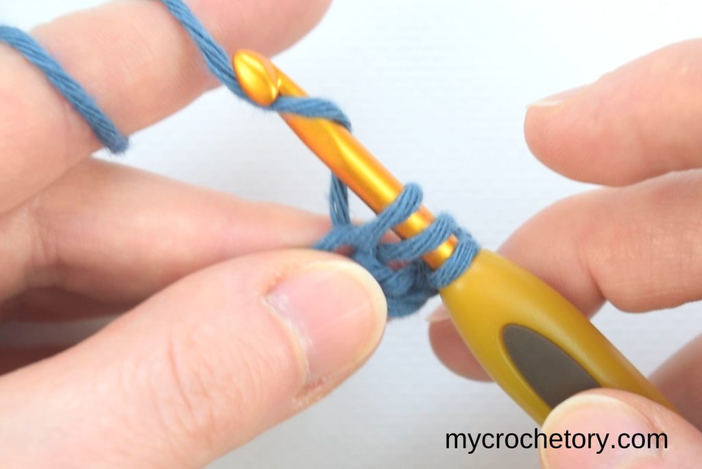How to double crochet for beginners: three loop on the hook and yarning over.