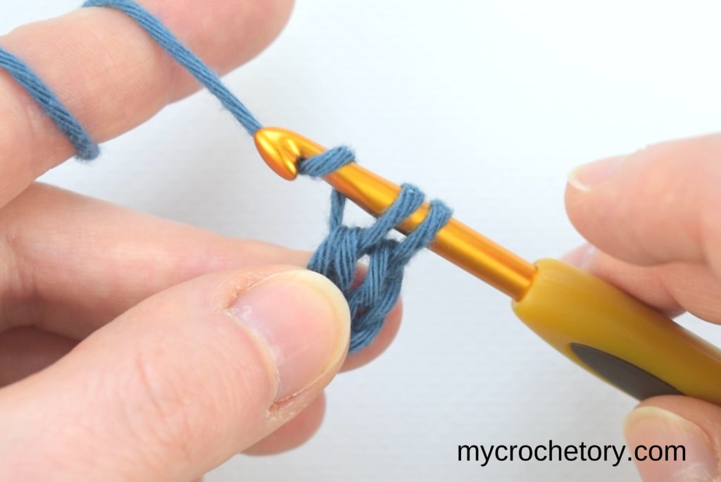 How to double crochet for beginners: two loops on the hook and yarning over.