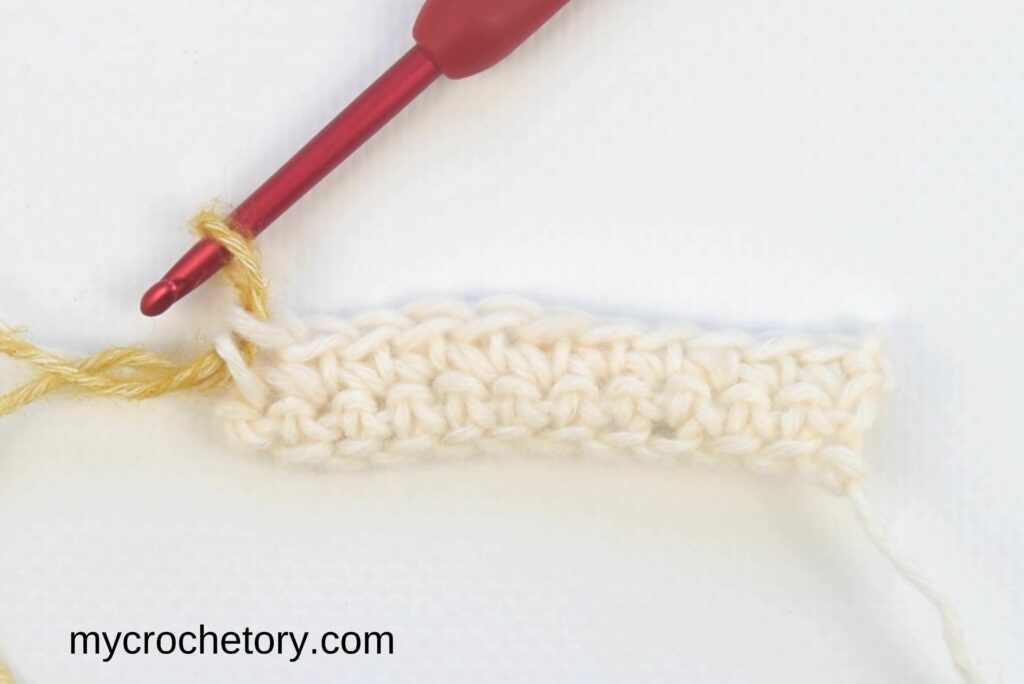 Mosaic crochet in rows: second row working on wrong side with new yarn color attached,