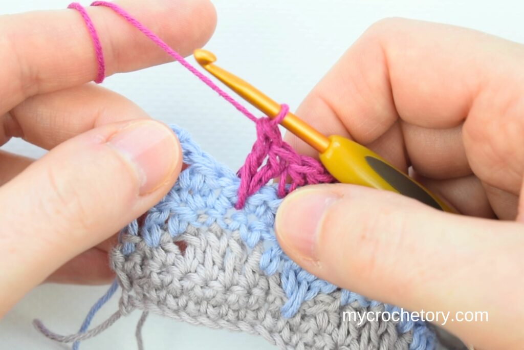 Hands demonstrating crochet stitches for crochet vs knitting yarn guide