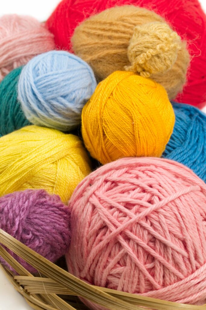 Various yarn types arranged by color for crochet vs knitting yarn choices