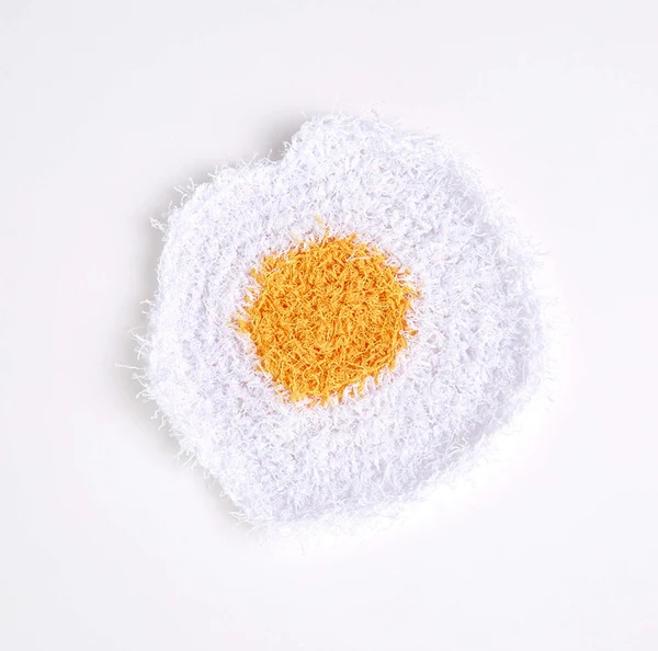 Red Heart Crochet Fried Egg Scrubby - white and yellow egg-shaped scrubby, perfect for scrubby yarn crochet patterns.