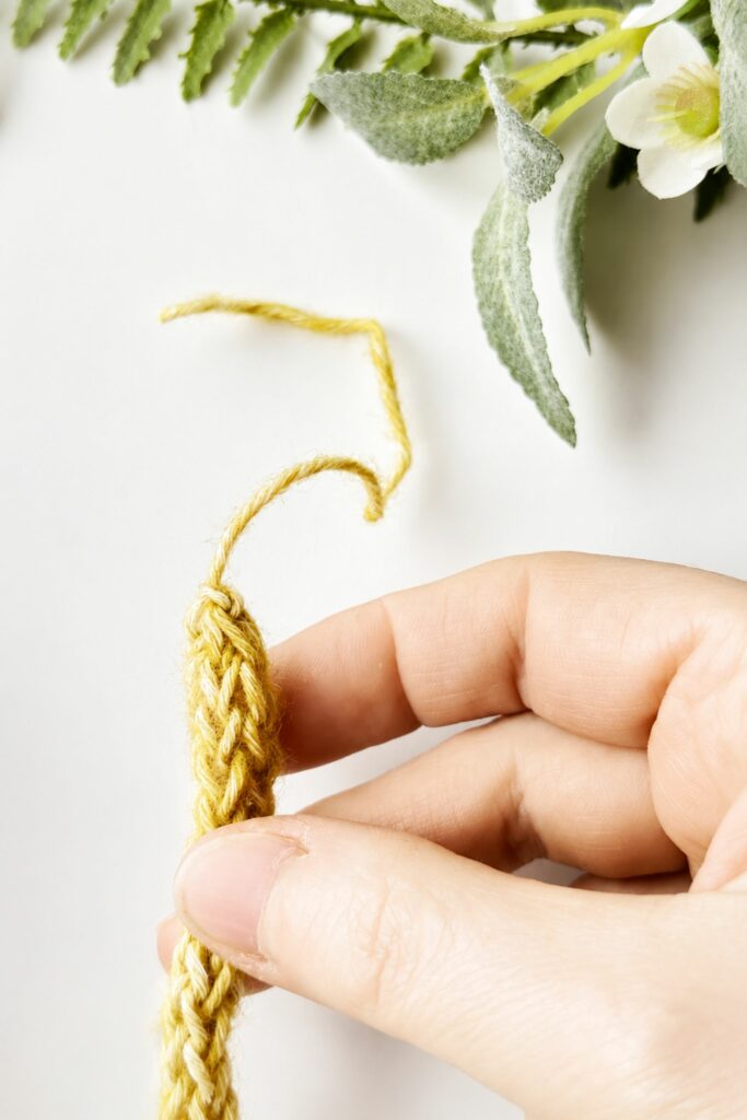 Finished yellow crochet I-Cord on a white background
