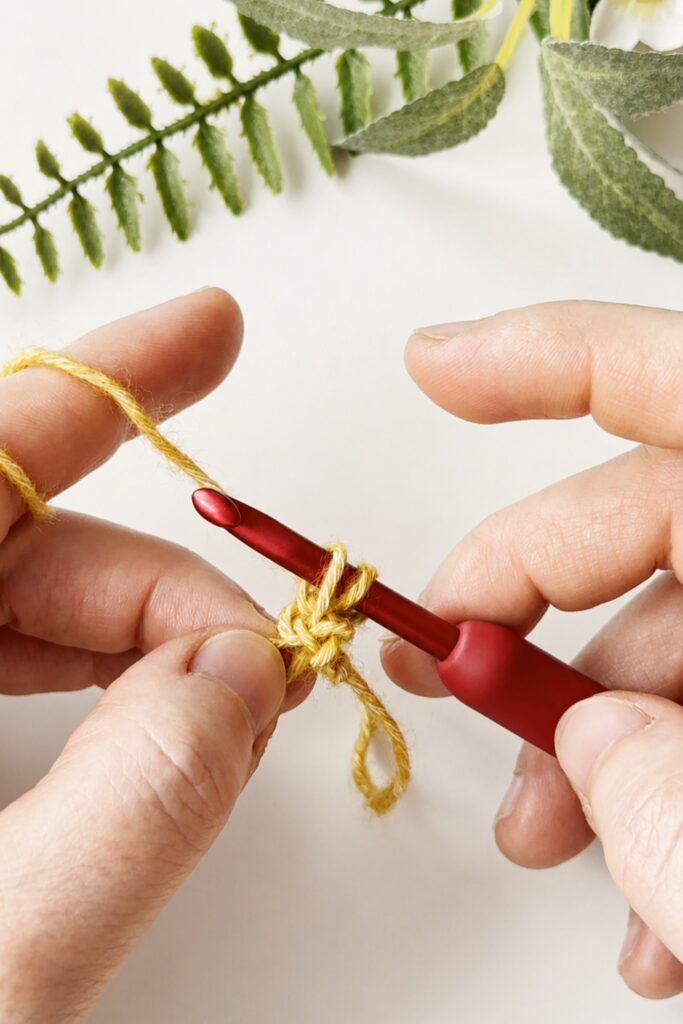 Hands holding dropped loops while learning how to crochet an I-Cord