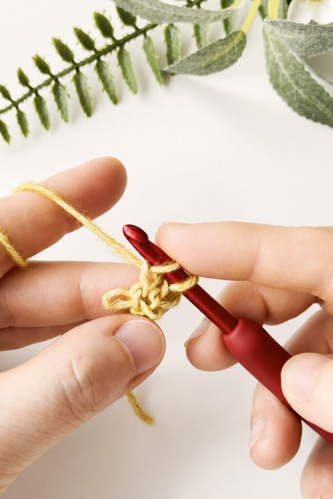 Close up of yellow yarn loops on a hook for a crochet I-Cord