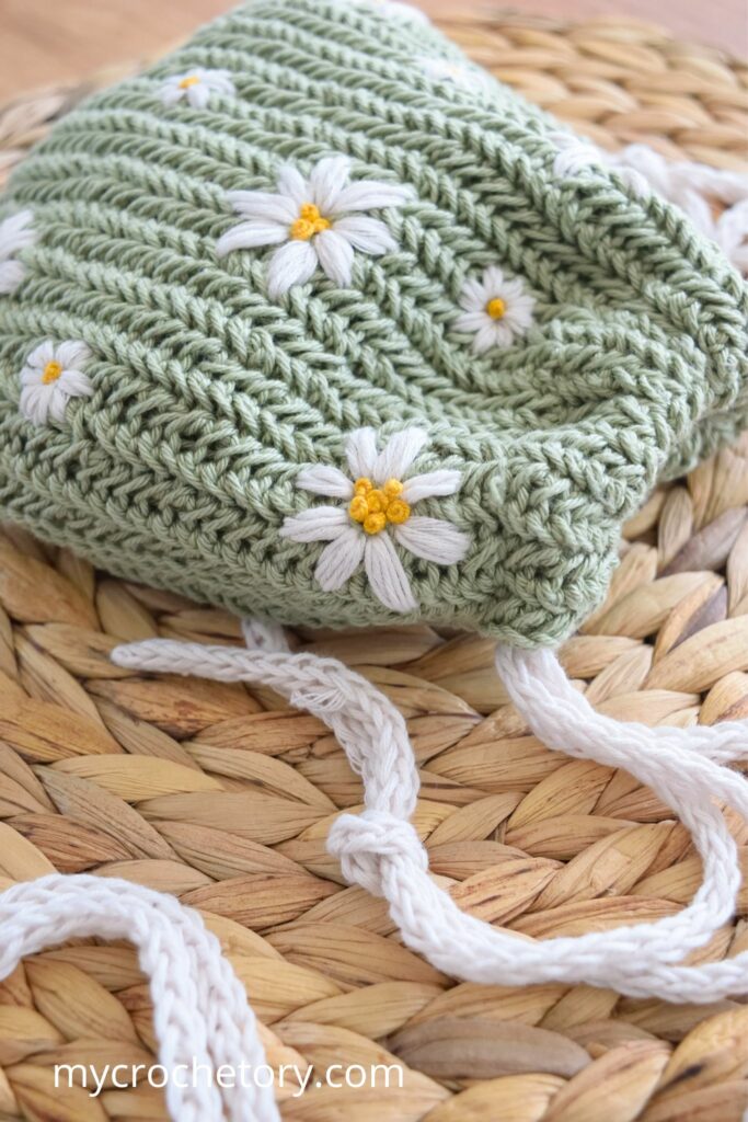 Green crochet drawstring bag pattern with daisy flowers