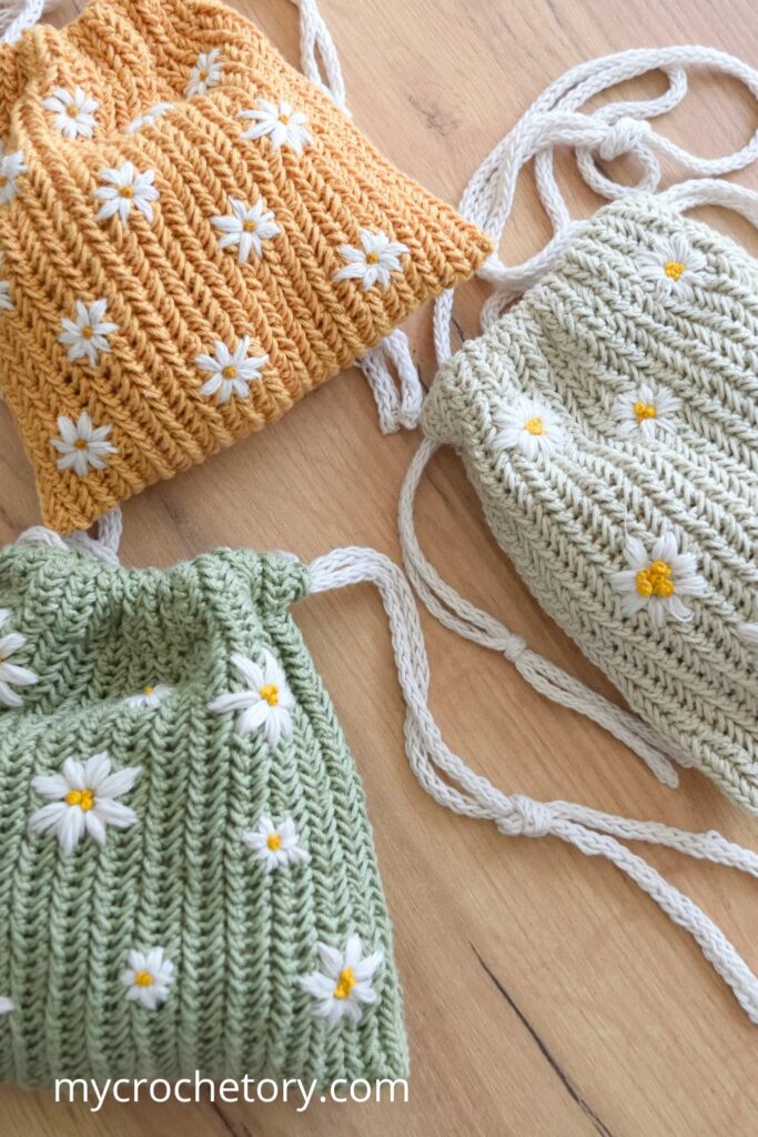 Stylish crochet drawstring bag pattern with daisy embroidery