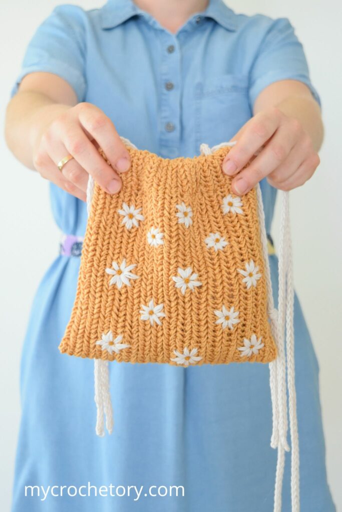 Woman holding a crochet drawstring bag pattern