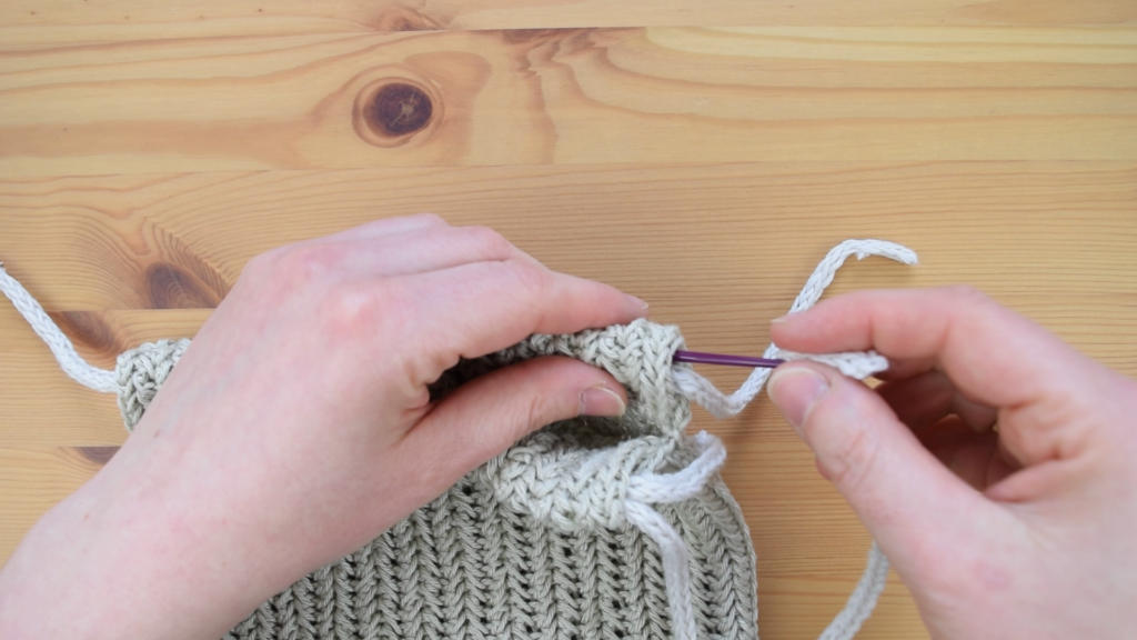 Final steps of threading I-cord in crochet drawstring bag pattern