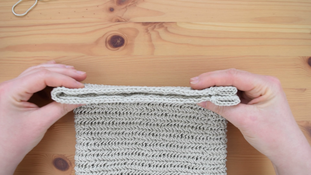 Folding the crochet piece to form the drawstring bag pattern