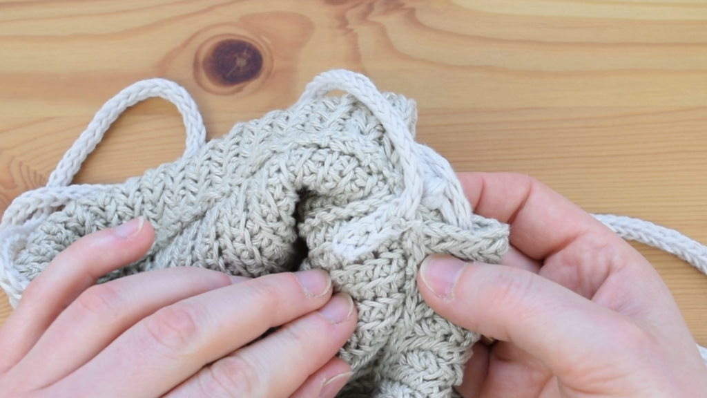 Close-up of securing the strap in crochet drawstring bag pattern