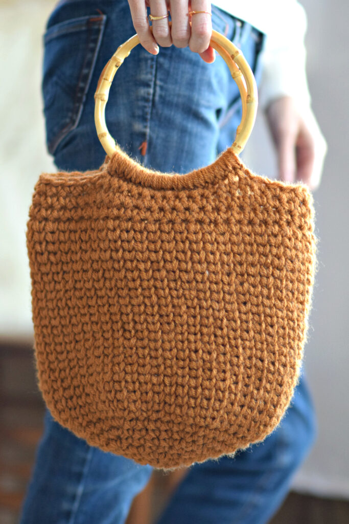 Neutral-toned crochet camel bucket bag with practical shape – versatile crochet bags patterns.
